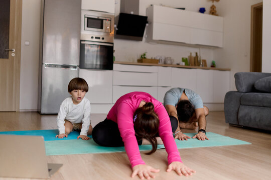 Family practicing yoga together at home
