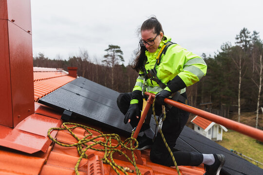 Technician Securing Safety Ropes for Solar Check