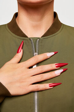 Woman showing matte pointed red nails with decoration