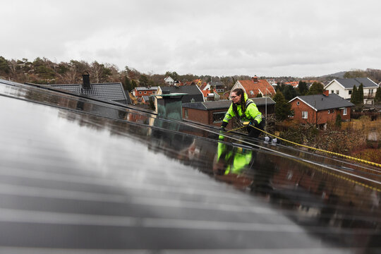 Technician Inspecting Large Solar Array on Roof