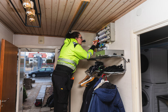 Technician Inspecting Electrical Fuse Box