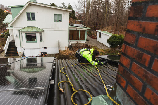 Professional Technician Inspecting Rooftop Solar Panels