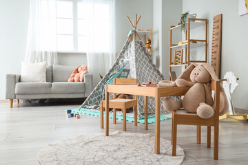 Interior of light playroom with play tent, table and sofa in kindergarten © Pixel-Shot