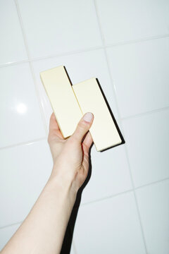 Hand holding yellow mockup packages with space for text or design 
