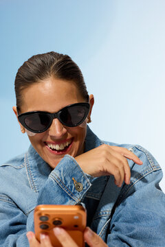 Woman in Sunglasses Enjoys Using Smartphone Outdoors
