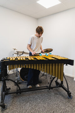 Young Male Musician Playing Marimba with Four Mallets in Music studio