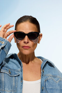 Woman Wearing Sunglasses in a Blue Denim Jacket Outdoors