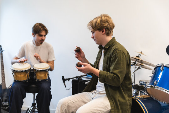 Two students playing percussion instruments together