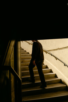 anonymous young m an walking upstairs outdoors 