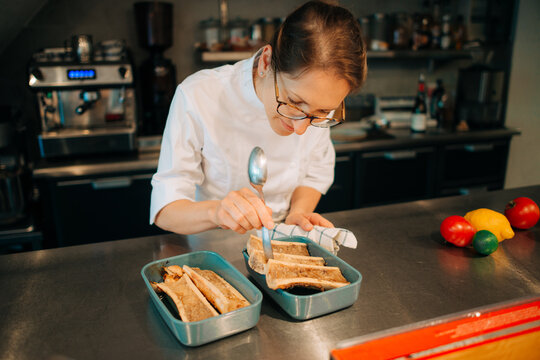 Chef working on roasted bone marrow dish in professional kitchen
