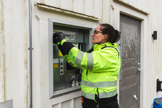 Female Electrician Inspecting Residential Electrical Panel