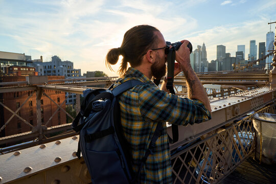 Man takes photos from the Brooklyn Bridge