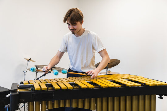 Young Male Musician Playing Marimba with Four Mallets in Music studio