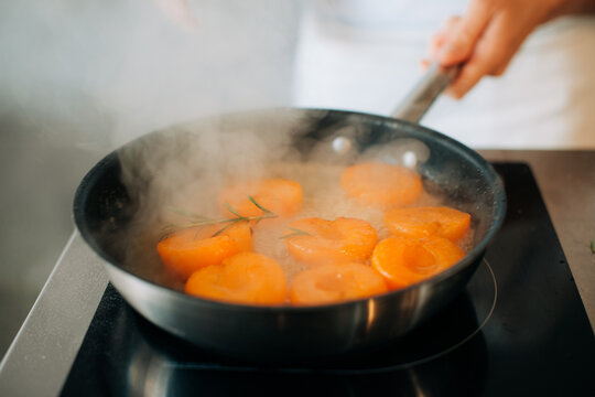 Apricots simmering with rosemary in pan