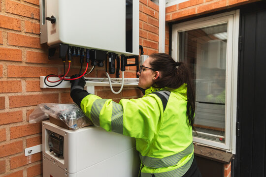 Technician Inspecting Electrical Cables and Inverter Connections