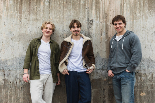 Three Diverse Young Friends Posing Together Against Urban Wall
