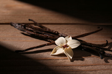 Obraz premium Vanilla sticks and flower on wooden background