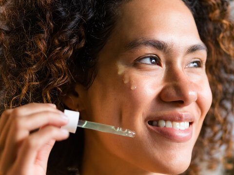 Woman enjoying using skincare serum 