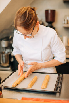 Chef shaping dough on baking tray in kitchen