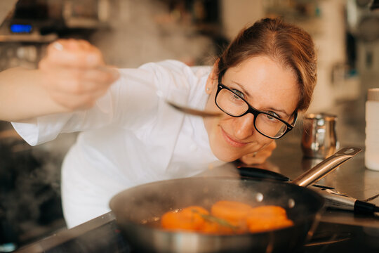 Chef tasting syrop while cooking apricots from pan