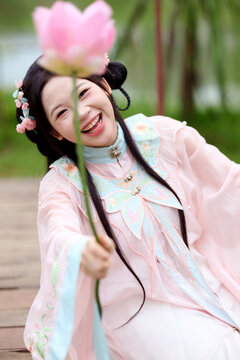 Chinese women dressed in ancient costumes play in a garden