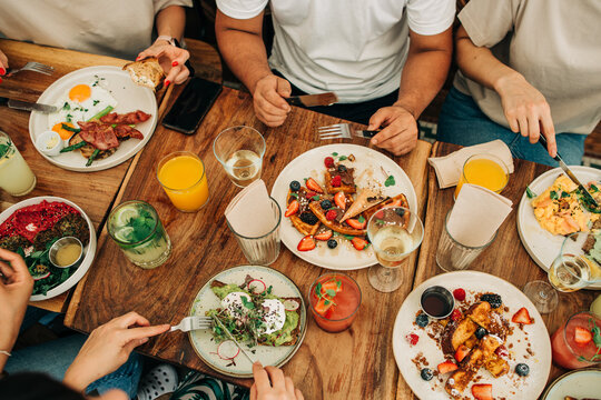 Group brunch table with waffles toast eggs and fresh drinks