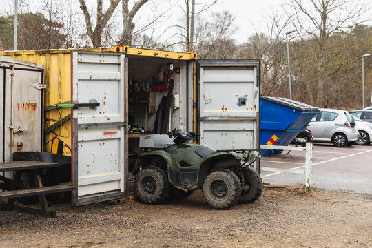 Green ATV Quad Bike Parked by Farm Storage Container