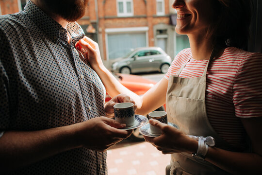 Close couple sharing coffee moment by window