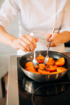 Chef turning caramelized apricots in pan during cooking process