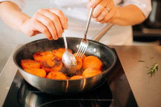 Anonymous chef cooking apricots in a pan