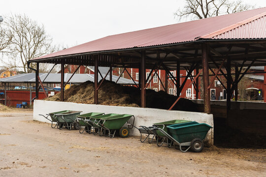 Horse Manure Storage Pit with Row of Green Wheelbarrows
