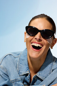 Woman Wearing Sunglasses Smiles While Relaxing Outdoors