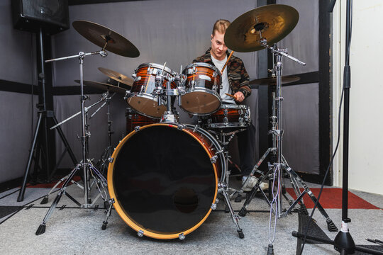 Focused Young Male Drummer Playing a Full Percussion Set