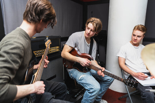 Band Members Collaborating and Writing Music in Rehearsal Space