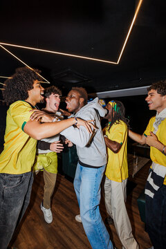 Excited sports fans celebrating a goal in a bar