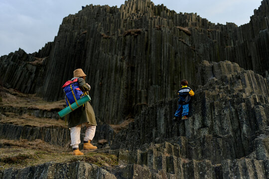 Parent and child exploring basalt rock formations