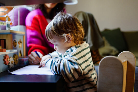 Toddler Drawing With Parent At Home Table