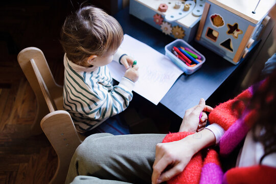 Parent and Toddler Drawing Together at Small Table