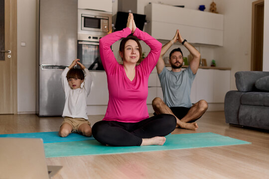Family practicing yoga together at home