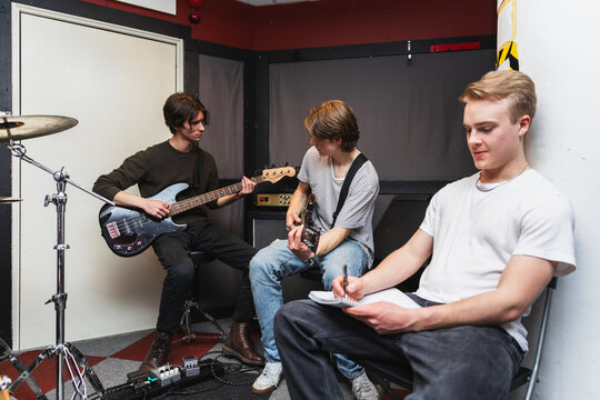 Band Members Collaborating and Writing Music in Rehearsal Space