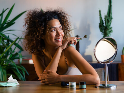 Happy woman posing with jade roller 