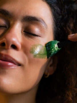 Woman Applying Green Mask on Her Face in a Beauty Session