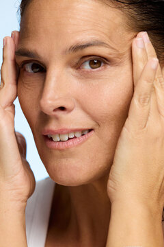 Woman Touching Her Face in a Natural Setting During Daylight Hours