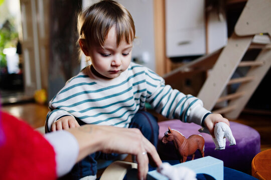 Toddler Playing With Toy Animals At Home