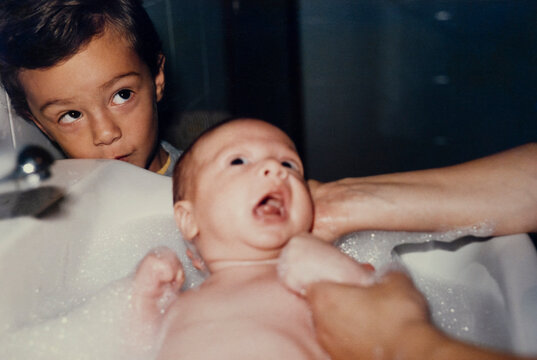 Baby bath time with sibling watching