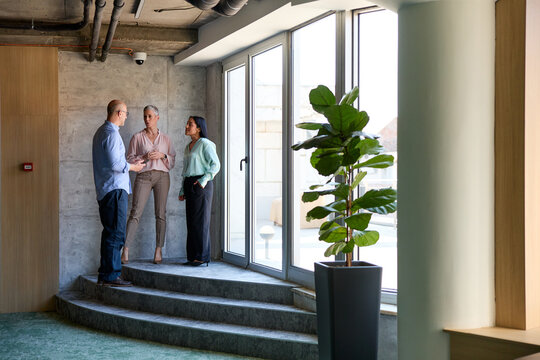 Small group of colleagues chat in the corporate setting