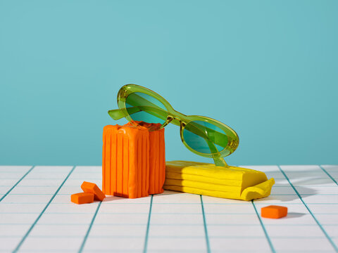 Vibrant still life with green sunglasses resting on colorful shapes