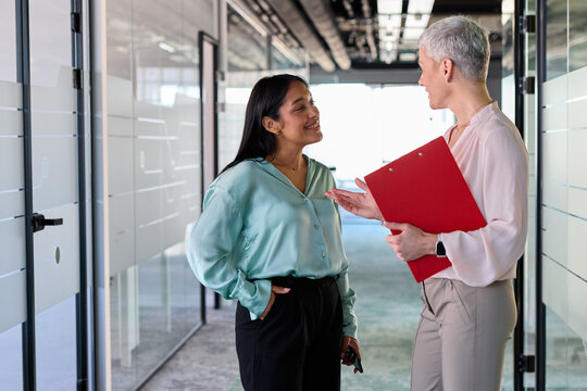 Businesswomen talk to each other in the hallway