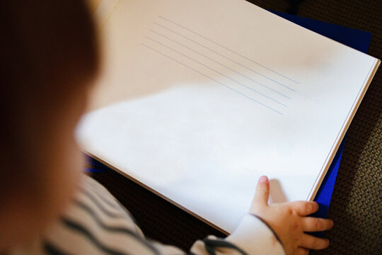 Toddler Holding Notebook With Blank Lined Page