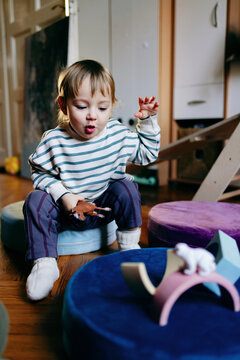 Toddler Playing With Toy Animals on Floor Cushions